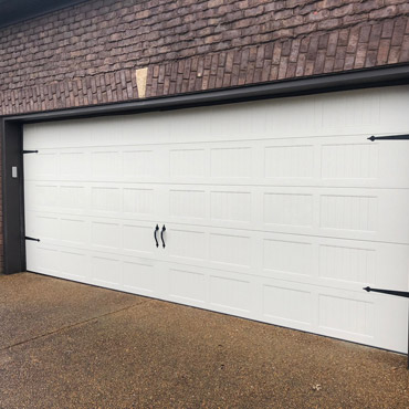 Residential property with a large, white garage door.